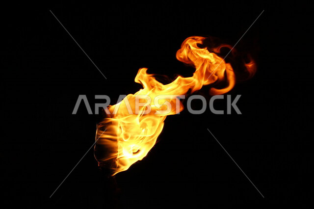 لهب النار على خلفية سوداء من الفن التجريدي ،  الشرارات الساخنة المحترقة ، صورة للنار المتوهجة برتقالية اللون