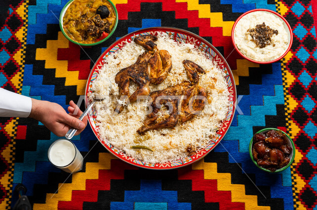 اكلات شعبية، رجل عربي خليجي سعودي يستخدم المعلقة في الاكل، اكلات عربية خليجية، طبق مكون من الارز والدجاج، طعام عربي شعبي خليجي، اشهر الاطباق القديمة للمطبخ السعودي، عزائم وولائم