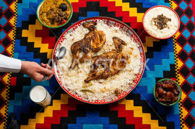 اكلات شعبية، رجل عربي خليجي سعودي يستخدم المعلقة في الاكل، اكلات عربية خليجية، طبق مكون من الارز والدجاج، طعام عربي شعبي خليجي، اشهر الاطباق القديمة للمطبخ السعودي، عزائم وولائم