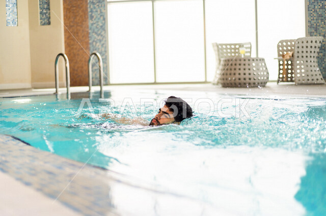 شاب عربي سعودي، متعة السباحة، التدرب على السباحة، الجلوس والاسترخاء في المسبح