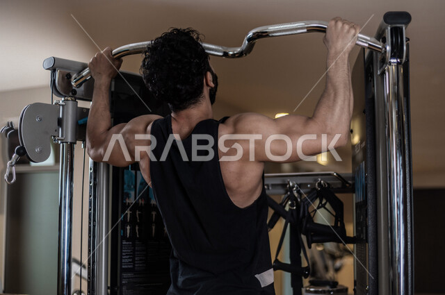 شاب عربي سعودي، التمرن في صالة كمال الاجسام، رفع الأثقال، كمال الأجسام، ممارسة الرياضة، اللياقة البدنية