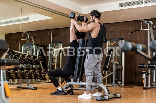 شاب عربي سعودي، التمرن في صالة كمال الاجسام، رفع الأثقال، كمال الأجسام، ممارسة الرياضة، اللياقة البدنية