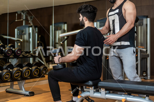 شاب عربي سعودي، التمرن في صالة كمال الاجسام، رفع الأثقال، كمال الأجسام، ممارسة الرياضة، اللياقة البدنية