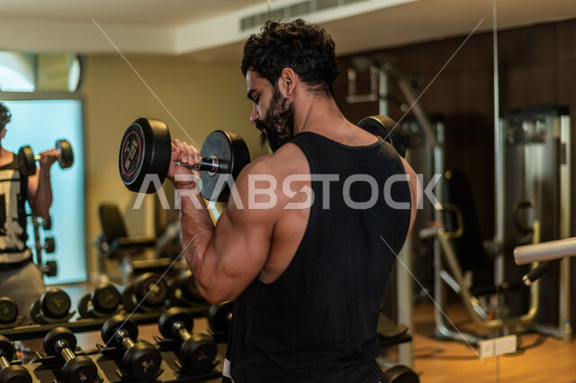 شاب عربي سعودي، التمرن في صالة كمال الاجسام، رفع الأثقال، كمال الأجسام، ممارسة الرياضة، اللياقة البدنية