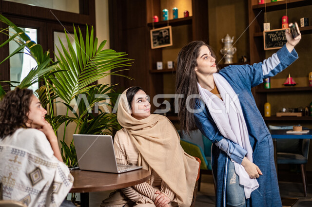 سيدات عربيات خليجيات سعوديات يستخدمن جهاز الحاسوب المحمول ، يقومون بالتقاط صورة سيلفي ، صورة تذكارية ،  سيدات أعمال ، اجتماع عمل ، انجاز مشاريع ، اجتماع صداقة