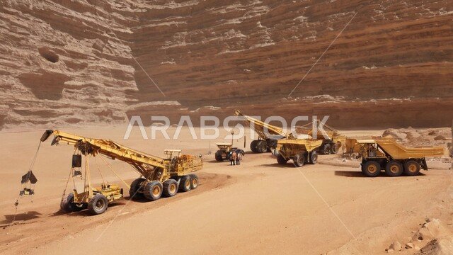 مفهوم مشاريع البناء والانشاء الكبيرة, جرافة هيدروليكية تقوم بأحد اعمال التعدين لنقل وتفريغ التراب في الأماكن الجبلية في المملكة العربية السعودية, مهن ووظائف هندسية صناعية, استخدام الآلات والمعدات الثقيلة في المناطق الوعرة في وقت النهار