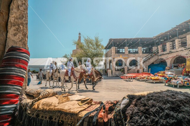 أزياء تراثية شعبية، رجال عرب خليجيين قطريين يمتطون الخيل العربي الأصيل في سوق واقف في الدوحة بقطر، أماكن ومعالم سياحية وتراثية في قطر، سوق واقف الشعبي