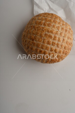 بسكوت المعمول الشعبية الهشة اللذيذة على ورق زبدة ، صورة لكعك بعجوة ويعرف بإسم كعك العيد الشهي ، خلفية بيضاء لحلويات شعبية طازجة