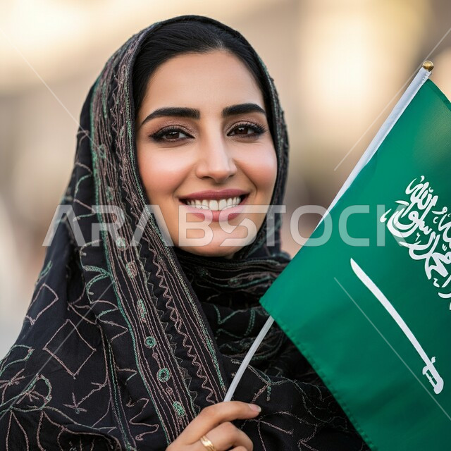 ذكرى العيد الوطني السعودي 23 سبتمبر, صورة مقربة لامرأة عربية سعودية خليجية محجبة ترتدي العباءة السوداء تحمل بيدها علم السعودية للاحتفال بيوم العلم 11مارس, التعبير عن الفخر والاعتزاز بالانتماء للمملكة