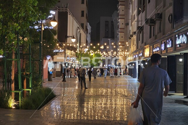 Famous religious landmarks and places at night, urban development and interest in shops and residential buildings, citizens walking in the illuminated Quba Street at night in Medina