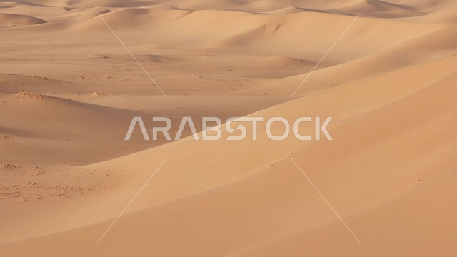 Terrain, heights and peaks in the prairies, sand formations and formations in the desert of the Kingdom of Saudi Arabia, desert areas and desert environment during the day, dunes and hills of soft golden sand