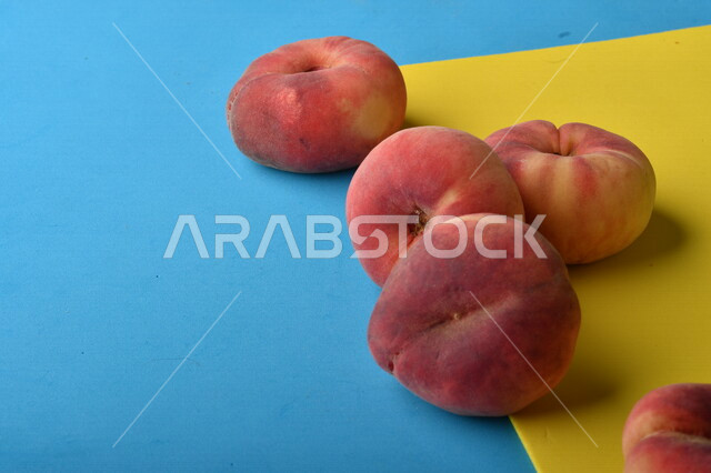 صورة لفاكهة الخوخ اللذيذ على خلفية ملونة باللونين الأصفر والأزرق ، فاكهة الدّراق الصحية اللذيذة ، فاكهة صيفية