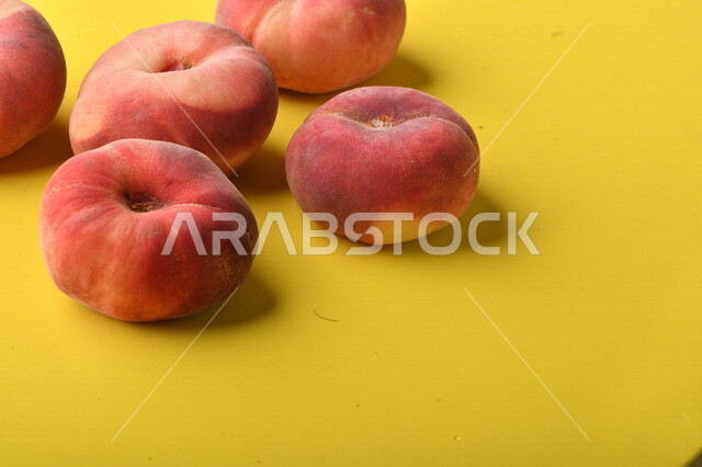 صورة لفاكهة الخوخ اللذيذ على خلفية ملونة باللونين الأصفر والأزرق ، فاكهة الدّراق الصحية اللذيذة ، فاكهة صيفية