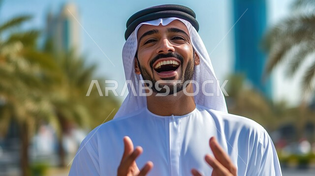 مفهوم الأناقة والاهتمام بالمظهر الخارجي، صورة مقربة لرجل عربي خليجي سعودي يرتدي الشماغ والثوب التقليدي ينظر الى الكاميرا بتعابير السرور والسعادة، ايماءات البهجة والضحك الشديد
