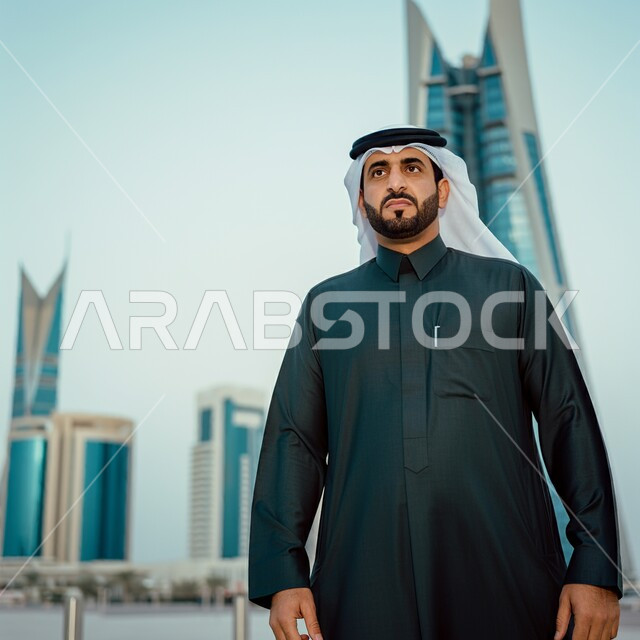 النظر إلى الكاميرا بإيماءات الرضا والسرور، صورة مقربة لشاب عربي خليجي سعودي مبتسم يرتدي الشماغ والثوب التقليدي، الاهتمام بالأناقة والمظهر الخارجي