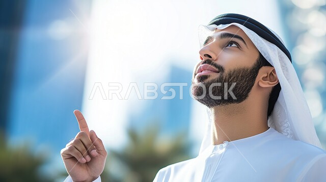 Making decisions and solving problems, a close-up picture of an Arab Gulf Emirati man wearing a kandura and a white Emirati ghutra, thinking and planning for the future, gestures of integration and absent-mindedness, looking at something and raising his index finger.