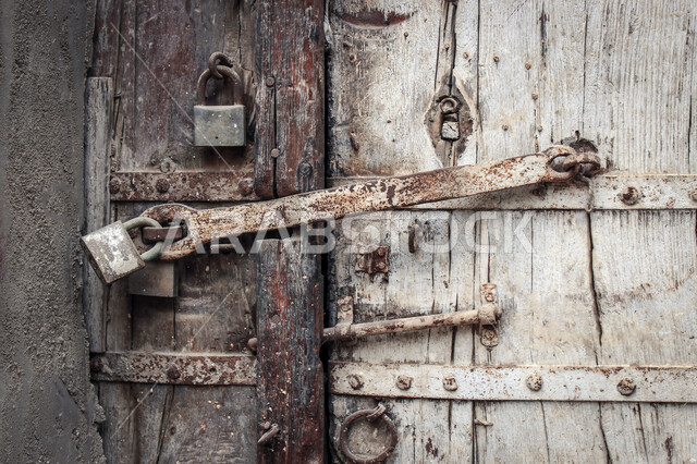 باب آثري قديم في السعودية بأسلوب تاريخي اسلامي ، معالم سياحة في المملكة العربية السعودية ، صورة خلفية لباب حجري قديم بارز الشكل ، باب قديم ، قفل نحاسي