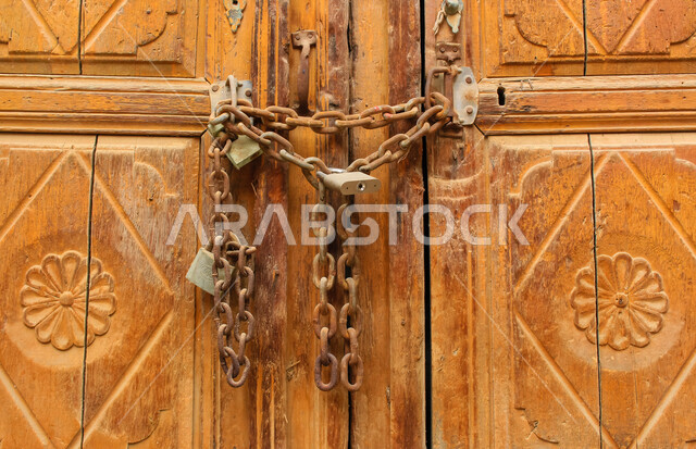 باب آثري قديم في السعودية بأسلوب تاريخي اسلامي ، معالم سياحة في المملكة العربية السعودية ، صورة خلفية لباب حجري قديم بارز الشكل ، باب قديم ، قفل نحاسي