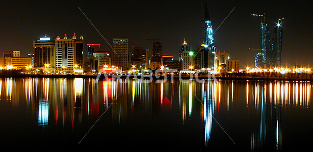 منظر انعكاس الأضواء على مياه البحر في المنامة, الفن الهندسي المعماري لبناء الأبراج و ناطحات السحاب, المباني الشاهقة و المنشآت التجارية و السكنية المضيئة ليلاً, أماكن و معالم سياحية ساحلية مشهورة في البحرين