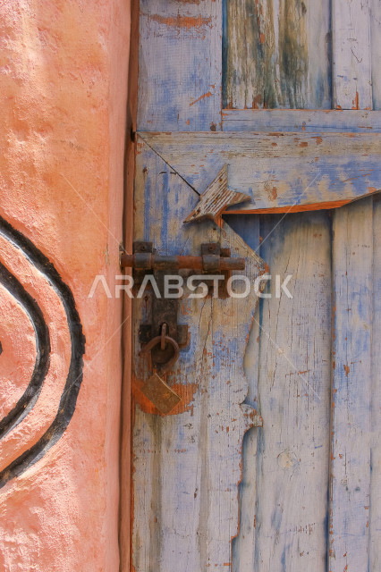 باب آثري قديم في السعودية بأسلوب تاريخي اسلامي ، معالم سياحة في المملكة العربية السعودية ، صورة خلفية لباب حجري قديم بارز الشكل ، باب قديم ، قفل نحاسي