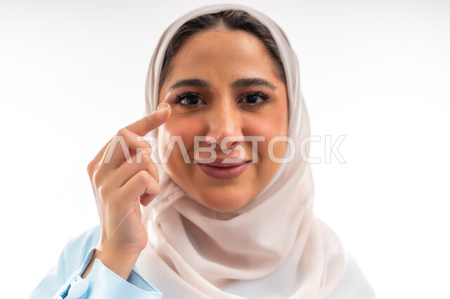 مفهوم الأنوثة والاهتمام بالجمال والبشرة والمظهر الخارجي, خبيرة سعودية لمستحضرات التجميل النسائية، بورتريه مقرب لإمرأة عربية خليجية عمانية ترتدي العباءة والحجاب، التسويق لمنتجات الميك اب، خلفية بيضاء