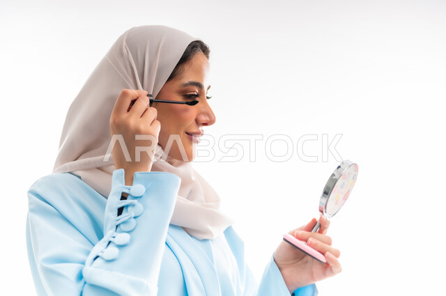 مفهوم الأنوثة والاهتمام بالجمال والبشرة والمظهر الخارجي, خبيرة سعودية لمستحضرات التجميل النسائية، بورتريه مقرب لإمرأة عربية خليجية عمانية ترتدي العباءة والحجاب، التسويق لمنتجات الميك اب، خلفية بيضاء