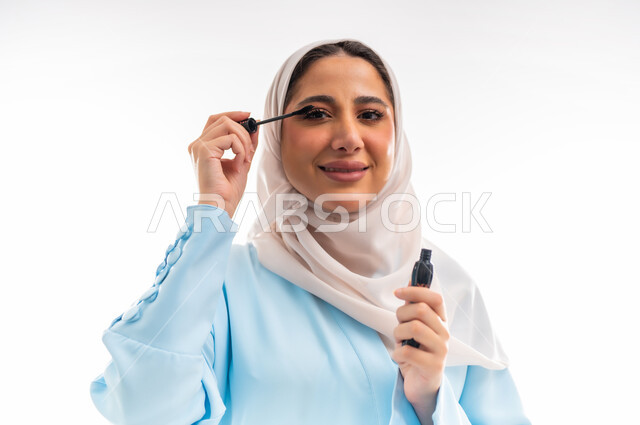 مفهوم الأنوثة والاهتمام بالجمال والبشرة والمظهر الخارجي, خبيرة سعودية لمستحضرات التجميل النسائية، بورتريه مقرب لإمرأة عربية خليجية عمانية ترتدي العباءة والحجاب، التسويق لمنتجات الميك اب، خلفية بيضاء