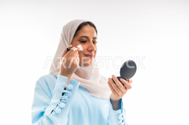 مفهوم الأنوثة والاهتمام بالجمال والبشرة والمظهر الخارجي, خبيرة سعودية لمستحضرات التجميل النسائية، بورتريه مقرب لإمرأة عربية خليجية عمانية ترتدي العباءة والحجاب، التسويق لمنتجات الميك اب، خلفية بيضاء