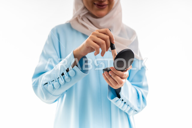 مفهوم الأنوثة والاهتمام بالجمال والبشرة والمظهر الخارجي, خبيرة سعودية لمستحضرات التجميل النسائية، بورتريه مقرب لإمرأة عربية خليجية عمانية ترتدي العباءة والحجاب، التسويق لمنتجات الميك اب، خلفية بيضاء