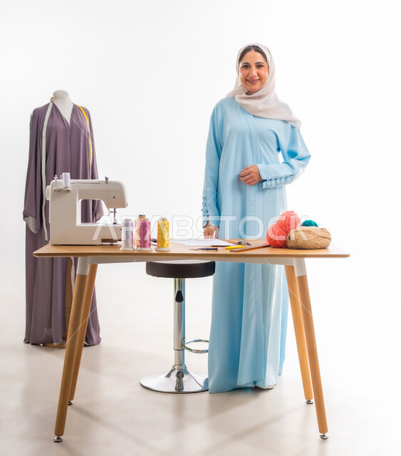 الوقوف باستعداد وثقة بالنفس، اختراع وابتكار تصاميم جديدة وعصرية، بورتريه لمرأة عمانية تنظر إلى الكاميرا بايماءات الفرح، أهمية المرأة في مجال الخياطة، ورشة عمل تصميم ازياء، مهن وأعمال فنية نسائية، فنون ومهارات تفصيل الملابس النسائية، مفهوم عالم الأزياء والموضة