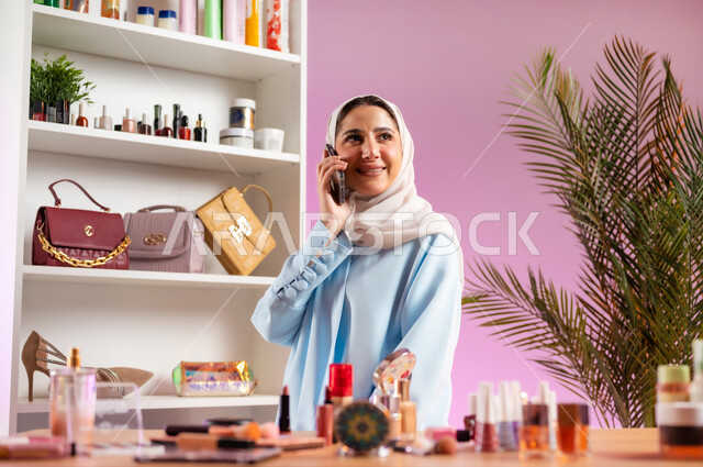 الدردشة مع الأهل والأصدقاء، إمرأة عربية خليجية عمانية ترتدي عباءة زرقاء تقوم بإجراء مكالمة هاتفية عبر الجوال، مفهوم الانوثه والاهتمام بالمظهر الخارجي, أدوات تجميل نسائيه عصريه، التسويق لمنتجات التجميل, مكياج وميكاب تتوريال, صالون نسائي راقي