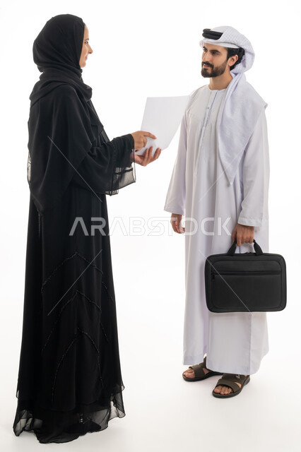 دراسة وتحليل المشاريع الجديدة، الشراكة والتعاون في إنجاز المهام، بورتريه لسيده ورجل عربيان خليجيان اماراتيان يرتديان الزي التقليدي الاماراتي يتشاركان دراسه جدوى ومناقشه اوراق العمل، خلفيه بيضاء