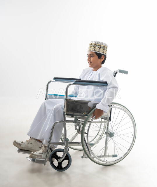 الاهتمام بالاطفال من ذوي الاحتياجات الخاصة في سلطنة عمان, تعابير السعادة والسرور والتفاؤل, بورتريه جانبي لطفل عربي خليجي عماني يرتدي الدشداشة و الكمه يجلس على كرسي متحرك, خلفية بيضاء