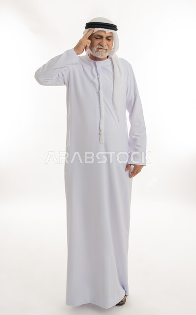 إيماءات الألم والتعب والمرض, الإحساس بوجع الرأس و الدوخة, آلام الشقيقة والصداع النصفي ,بورتريه لرجل كبير السن عربي خليجي اماراتي يرتدي الغترة والكندورة يضع يده على رأسه ويشعر بالدوار, الحاجة للعلاج والراحة، الجسم بالطول الكامل، خلفية بيضاء