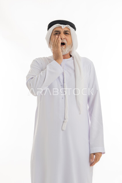 إيماءات التألم والتعب والمرض, بورتريه مقرب لرجل كبير السن عربي خليجي اماراتي يرتدي الغترة والكندورة يضع يديه على خده بتعابير الألم, الإحساس بوجع الأسنان والنخور، الحاجة للعلاج والذهاب للعيادة السنية، خلفية بيضاء