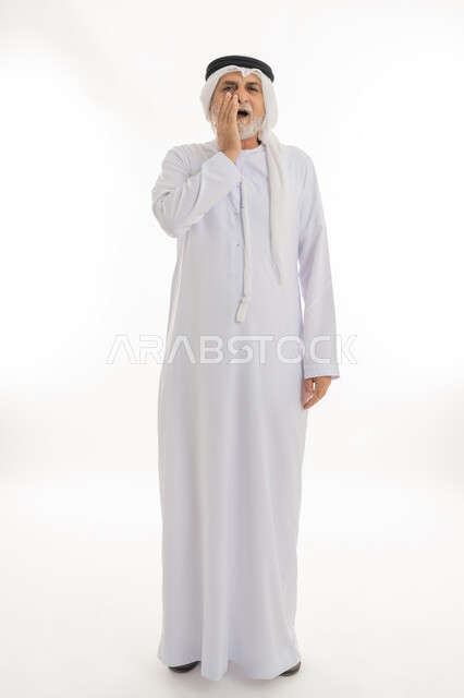 الشعور بالتعب والمرض, بورتريه لرجل كبير السن عربي خليجي إماراتي يرتدي الغترة والكندورة يضع يديه على خده بتعابير الألم, الإحساس بوجع الأسنان والتألم من النخور، الحاجة للعلاج والذهاب للعيادة السنية، الجسم بالطول الكامل، خلفية بيضاء