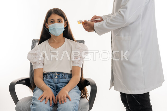 الحماية من الأمراض والمحافظة على السلامة، تجنب انتشار العدوى، طبيب يرتدي المعطف الأبيض والقفازات يقوم بتجهيز جرعة لقاح كوفيد-19، بورتريه لفتاة عربية خليجية اماراتية ترتدي الكمامة تستعد لتلقي اللقاح، اتباع إجراءات وزارة الصحة الوقائية، إتاحة التطعيم ضد فايروس كورونا، خلفية بيضاء