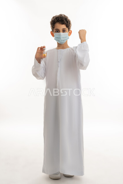 تجنب إنتشار العدوى، اتباع اجراءات وزارة الصحة الوقائية، مفهوم الوعي الصحي، الحماية من الأمراض والحفاظ على السلامة، التطعيم الآمن لكوفيد19، بورتريه لولد عربي خليجي إماراتي يرتدي الكندورة والكمامة يحمل بيده جرعة من لقاح فايروس كورونا، خلفية بيضاء