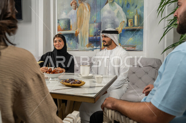 تعابير السعادة والسرور، النقاش والحوار في الأجواء الهادئة، مشاركة المشروبات الساخنة والقهوة والحلويات، بناء علاقات اجتماعية ناجحة بين الأشخاص، قضاء أوقات ممتعة مع الأصدقاء، صورة مقربة لزملاء عربيين خليجيين اماراتيين مبتسمين يجلسون في إحدى المقاهي الراقية