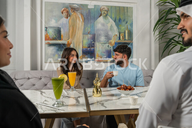 مشاركة المشروبات الباردة والقهوة والحلويات، النقاشات والحوارات في الأجواء الهادئة، بناء علاقات اجتماعية ناجحة بين الأشخاص، قضاء أوقات ممتعة مع الأصدقاء، صورة مقربة لزملاء عربيين خليجيين اماراتيين مبتسمين يجلسون في إحدى المقاهي الراقية بتعابير السعادة والسرور
