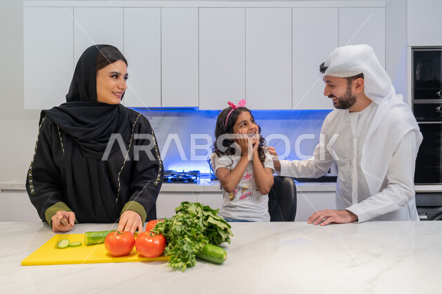 تعلم وصفات جديدة، قضاء اوقات عائلية ممتعة، تحضير والمأكولات الشهية، عائلة عربية خليجية اماراتية تقف أمام طاولة عليها مجموعة من الخضراوات  في المطبخ، اتباع نظام غذائي صحي، إعداد السلطات والأطباق المفيدة، المشاركة بالأعمال المنزلية