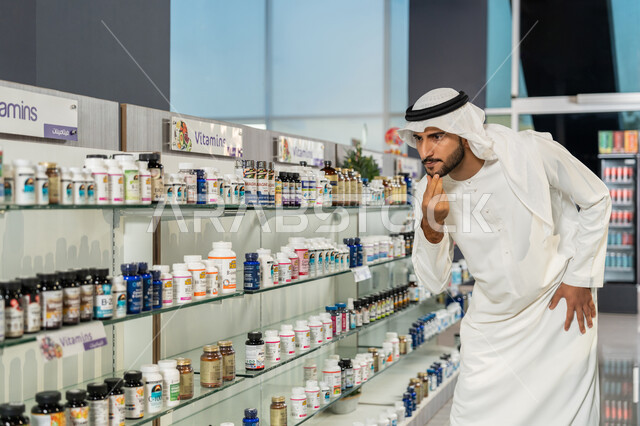 تفقد المنتجات والأدوات الطبية، رجل عربي خليجي اماراتي يرتدي الغترة والكندورة البيضاء يبحث داخل الصيدلية ويختار بعض المستلزمات، طلب الادوية الموجودة في الوصفة الطبية، شراء الادوية والعقاقير الطبية، الاستفادة من الخدمات الصحية