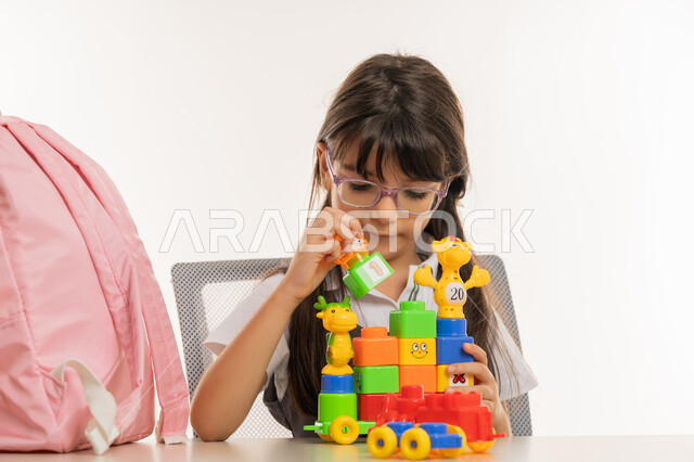 تلميذة مجتهدة في إحدى المدراس الأكاديمية, تعزيز الابتكارات باستخدام نظام المنتسوري للتعليم الذكي, تنمية القدرات الحركية والذهنية لدى الأطفال, آفاق ومهارات التعليم عن طريق اللعب, بورتريه مقرب لطالبه عربية خليجية إماراتية في بيئة تعليمية حديثة, خلفية بيضاء