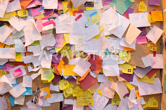 صورة لجدار مغطى بملاحظات واقتباسات فكاهيه وجميلة من أشخاص في أحد الأماكن الجميلة في المملكة العربية السعودية