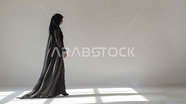 The art of distinctive modern Gulf abayas designs, a portrait of a Saudi Arabian Gulf model wearing an abaya and hijab, displaying fashion models for veiled women, the concept of elegance and interest in fashion, the elegance of Saudi women, gray background