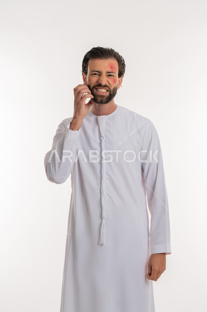 الشعور بالأوجاع والالام, المشاكل الصحية والتهجيات، الإصابة بالحساسية الجلدية, بثور منتشرة على بشرة الوجه, بورتريه لرجل عربي خليجي اماراتي يرتدي الكندورة يقوم بالحك بإيماءات الإنزعاج والتعب, خلفية بيضاء