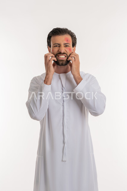 الشعور بالأوجاع والالام, المشاكل الصحية والتهجيات، الإصابة بالحساسية الجلدية, بثور منتشرة على بشرة الوجه, بورتريه لرجل عربي خليجي اماراتي يرتدي الكندورة يقوم بالحك بإيماءات الإنزعاج والتعب, خلفية بيضاء