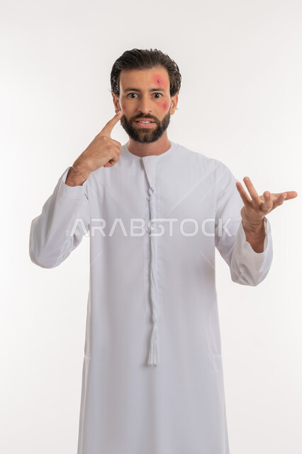 ايماءات التوتر والانزعاج، المشاكل الصحية وتهجيات الجلد, الإشارة إلى مكان الإصابة, بثور منتشرة على بشرة الوجه, بورتريه لرجل عربي خليجي اماراتي يرتدي الكندورة يرفع يده بإيماءات السؤال والاستفسار, خلفية بيضاء