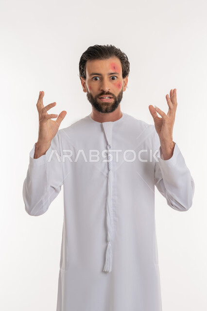 تعابير التوتر والانزعاج، الطفح الجلدي والأمراض المعدية, بورتريه لشاب عربي خليجي اماراتي يرتدي الكندورة يرفع يديه الى الاعلى, المشاكل الصحية وتهيجات الجلد, بثور منتشرة على بشرة الوجه, الإصابة الجلدية وفرط التحسس, خلفية بيضاء
