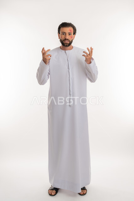 ايماءات التوتر والانزعاج، الطفح الجلدي والأمراض المعدية, بورتريه لشاب عربي خليجي اماراتي يرتدي الكندورة يرفع يديه الى الاعلى, المشاكل الصحية وتهيجات الجلد, بثور منتشرة على بشرة الوجه, الإصابة الجلدية وفرط التحسس, صورة لكامل الجسم، خلفية بيضاء
